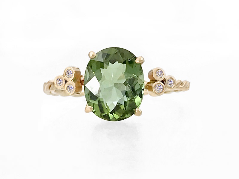 7-anel-de-noivado-com-pedra-central-de-turmalina oval-verde-e-diamantes-nos-detalhes-laterais